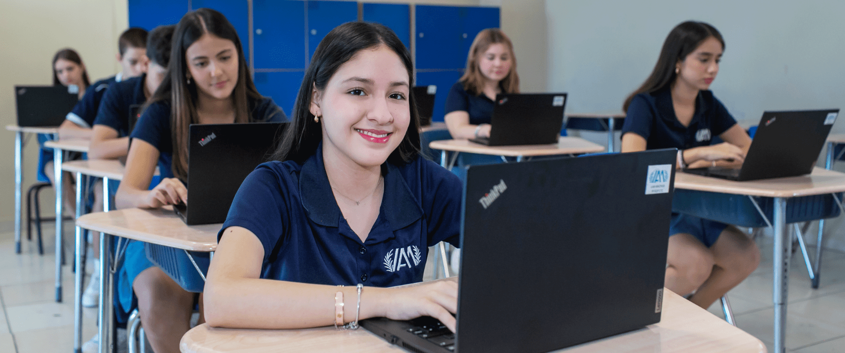 Alumna de Preparatoria del Instituto Anglo Moderno sonriendo frente a su computadora portátil